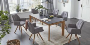 Graue Stühle aus Stoff mit Holzbeinen und einem passenden Holztisch mit grauer Fläche